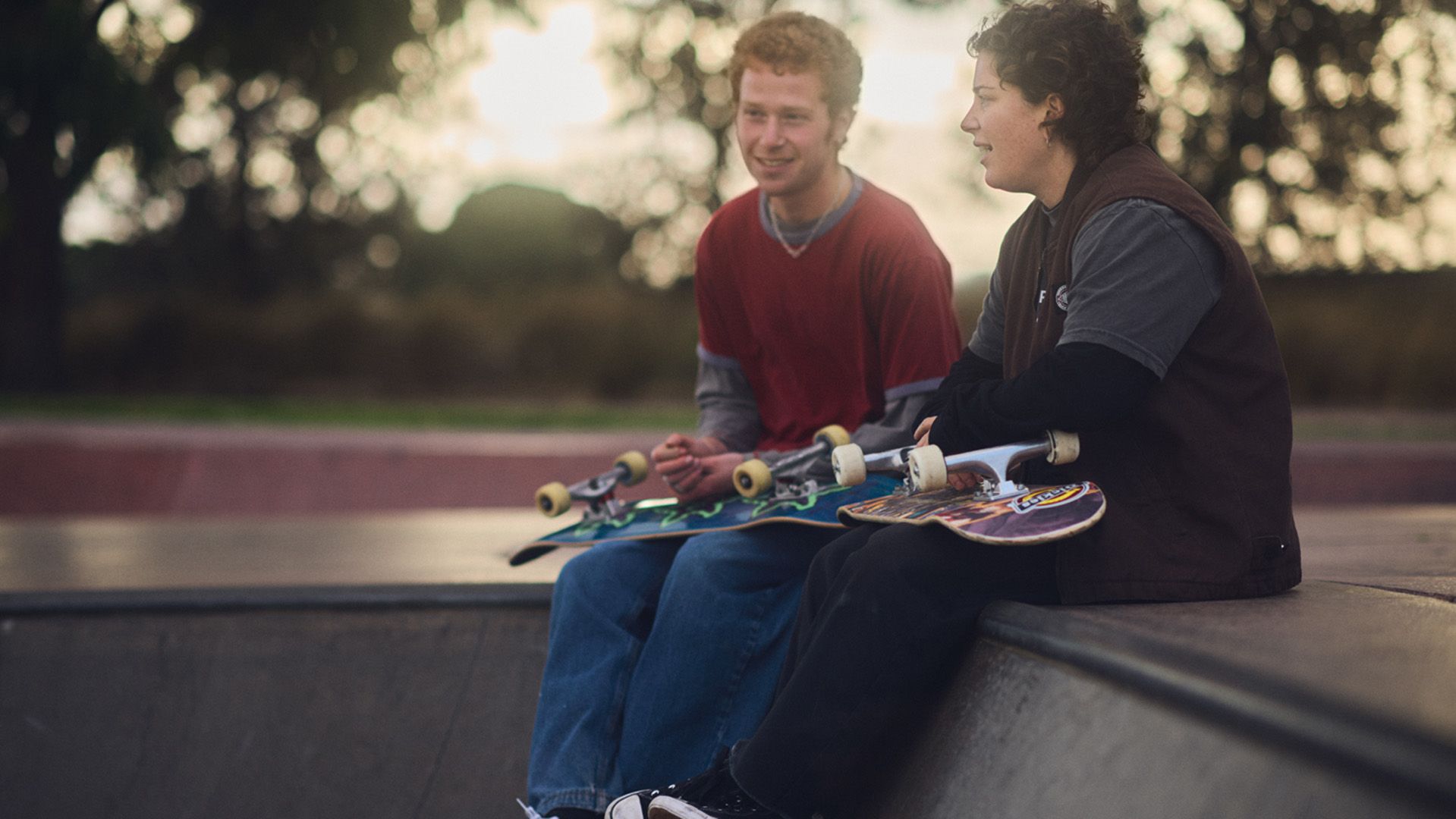 Photo of two young men hanging out at a skate park.