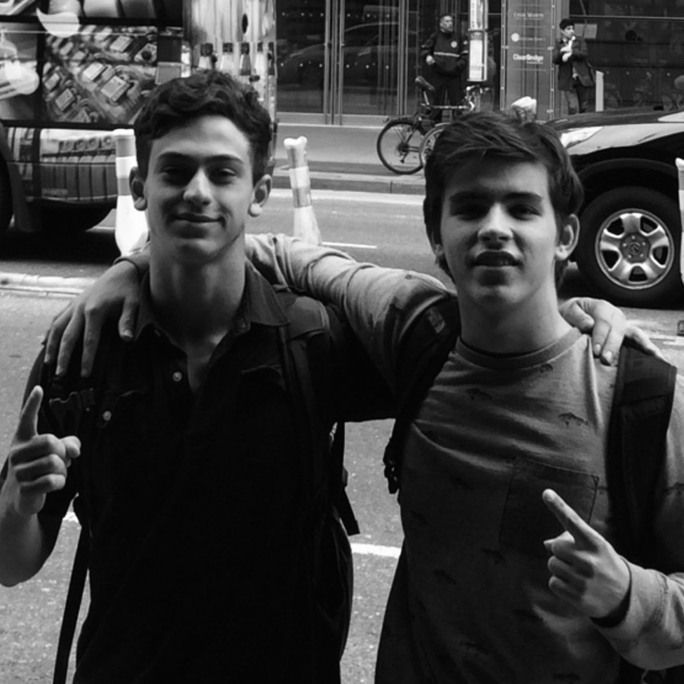 Black and white photo of two young men, looking optimistically to camera.